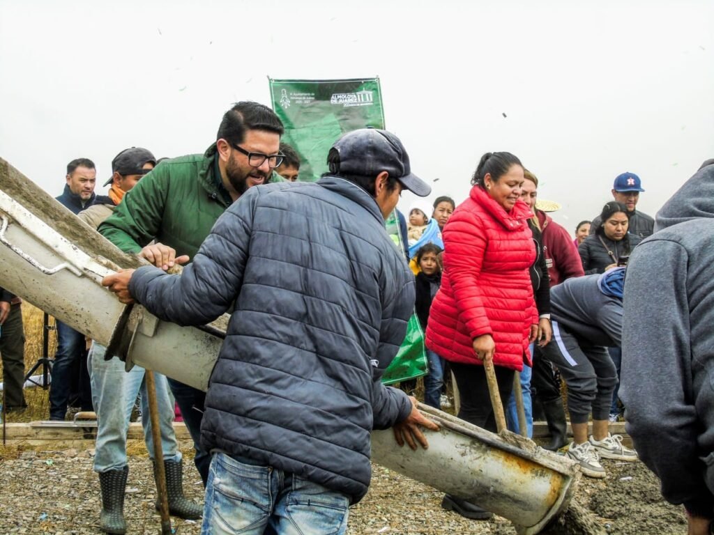 Mantiene Adolfo Solis el trabajo en las comunidades en vísperas de Navidad y cierra el año con más obras y entrega de juguetes a menores. En vísperas de Navidad y sin disminuir el ritmo de trabajo, el Gobierno de Almoloya de Juárez mantiene la atención a las comunidades. Por ello, el Presidente municipal, Adolfo Solis Gómez, realizó llevó el programa Pueblo y Gobierno a la comunidad Ampliación Benito Juárez, cerrando el año como lo inició: con trabajo y cercanía con la ciudadanía. Pese al intenso frío y la neblina, la jornada reunió a vecinas y vecinos que participaron en la mejora de un camino comunal con concreto hidráulico, ya que esta obra fortalece la movilidad y contribuye al bienestar de las familias de la zona. Las labores se desarrollaron mediante una faena comunitaria, en la que participó el alcalde, impulsando la colaboración entre sociedad y autoridades como base del desarrollo local. Bajo este esquema, el Ayuntamiento aporta los materiales necesarios, mientras que la población contribuye con mano de obra, consolidando un esfuerzo compartido en beneficio común. Durante su visita, el mandatario municipal convivió con las familias de la comunidad y, como parte de las actividades navideñas repartió juguetes a niñas y niños, así como canastas alimentarias a las y los vecinos. El programa Pueblo y Gobierno también ha llegado a comunidades como La Lima, Ejido Santa María, San Lorenzo y Buenavista, entre otras, donde se han impulsado mejoras en infraestructura básica a través del trabajo conjunto.